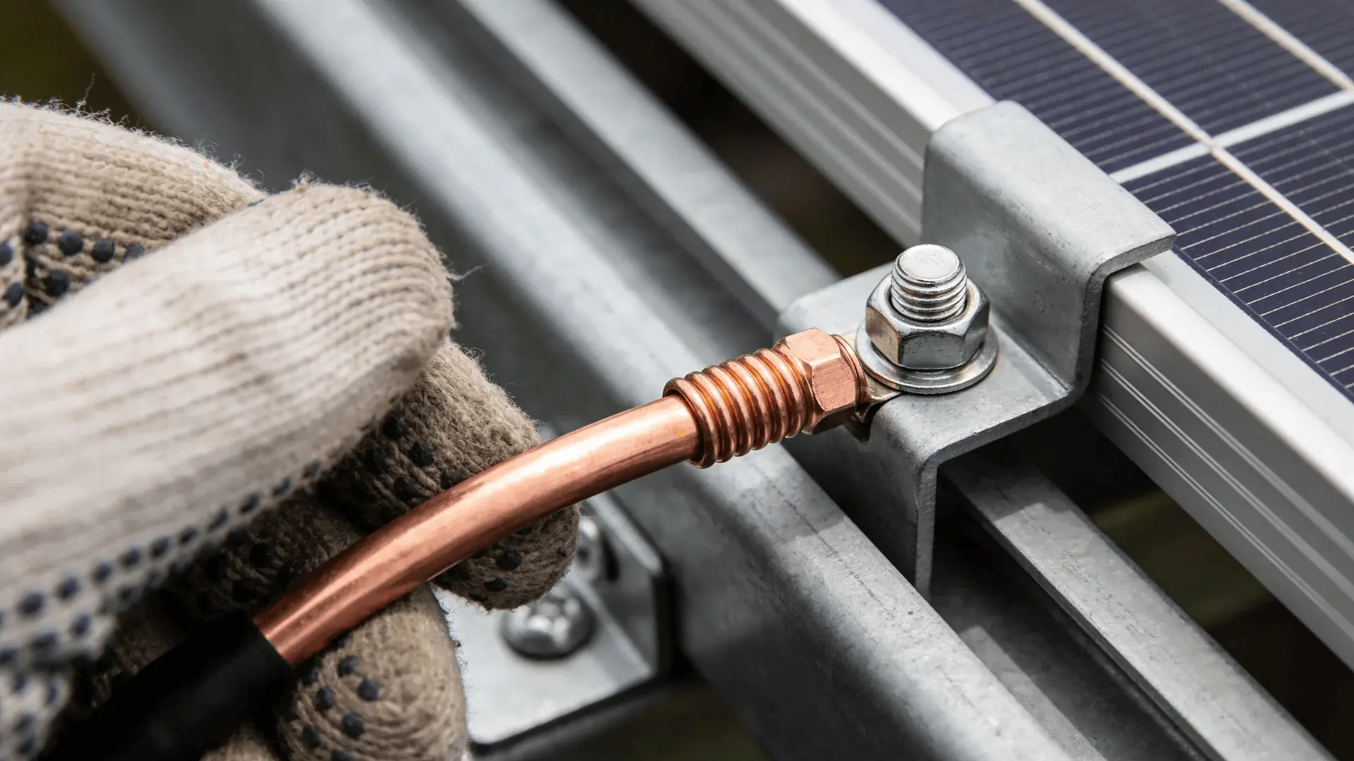 Copper grounding wire attached to solar panel frame and rail