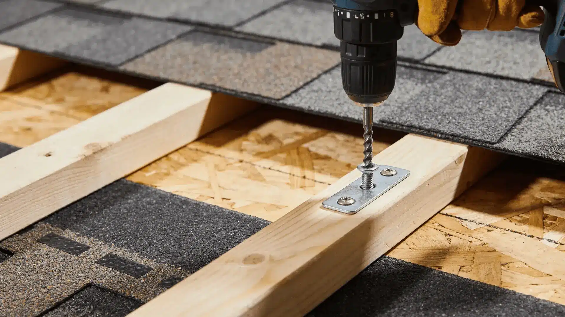 Installer securing roof mount with lag bolt into wooden rafter under shingles