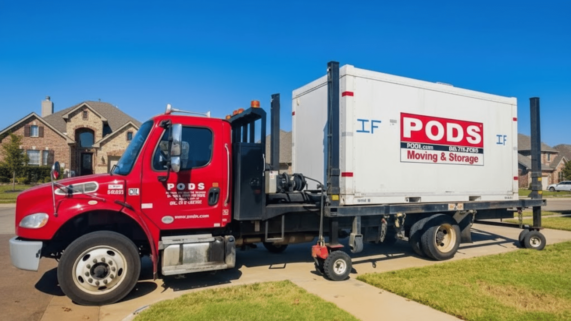 a pods moving truck delivers a white storage container to a suburban driveway with houses and lawns under a clear blue sky