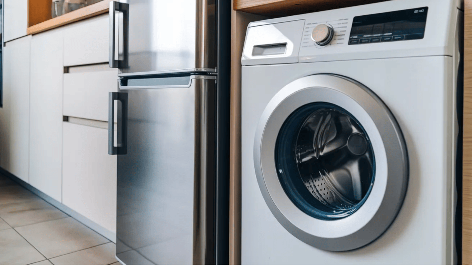 front-load washing machine beside a stainless steel refrigerator in a modern kitchen with white cabinets