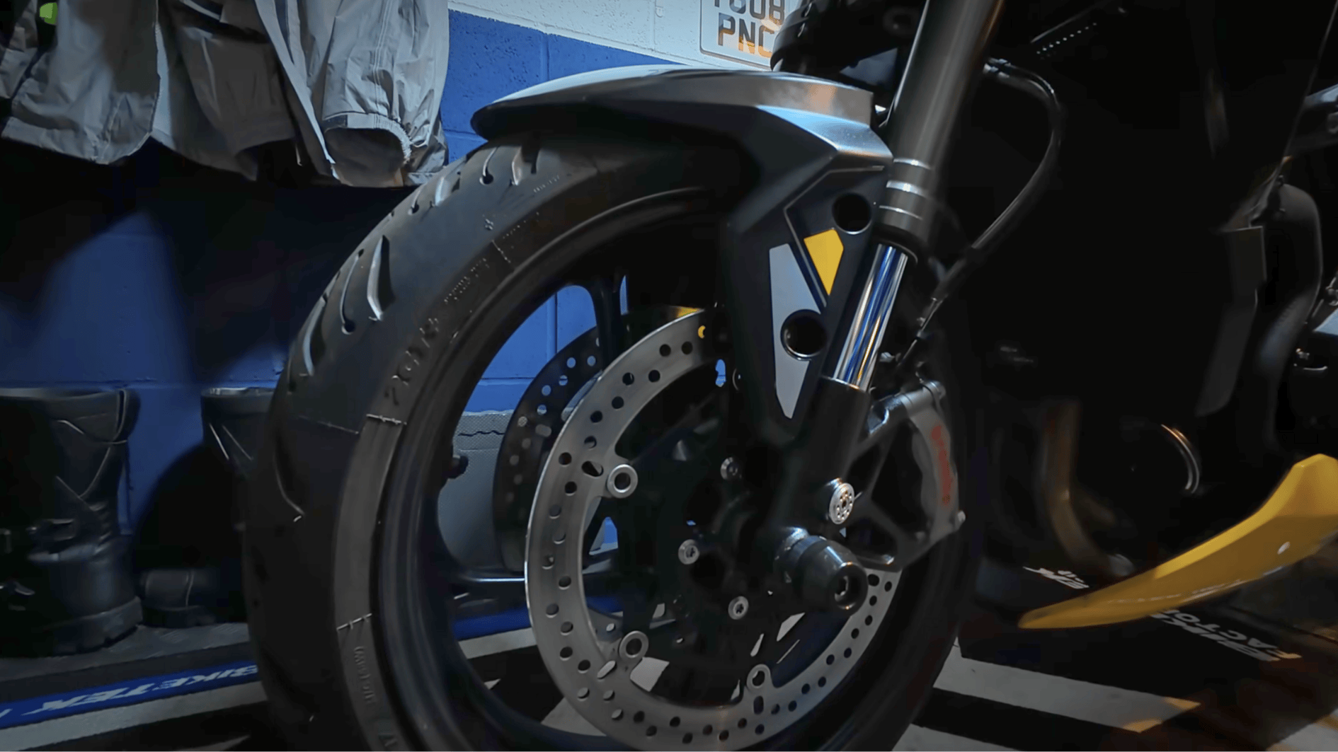 front wheel and brake disc of motorcycle cleaned and inspected before long-term winter storage indoors