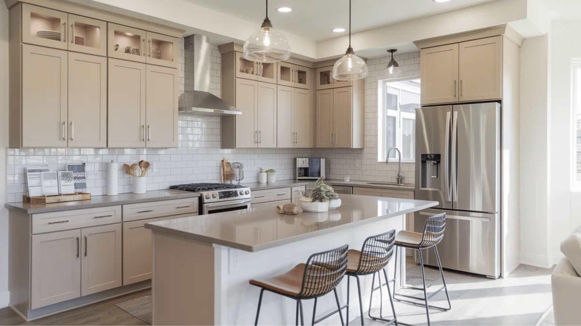 mid-range kitchen remodel with updated cabinets, quartz island countertop, stainless steel appliances, subway tile backsplash and pendant lights