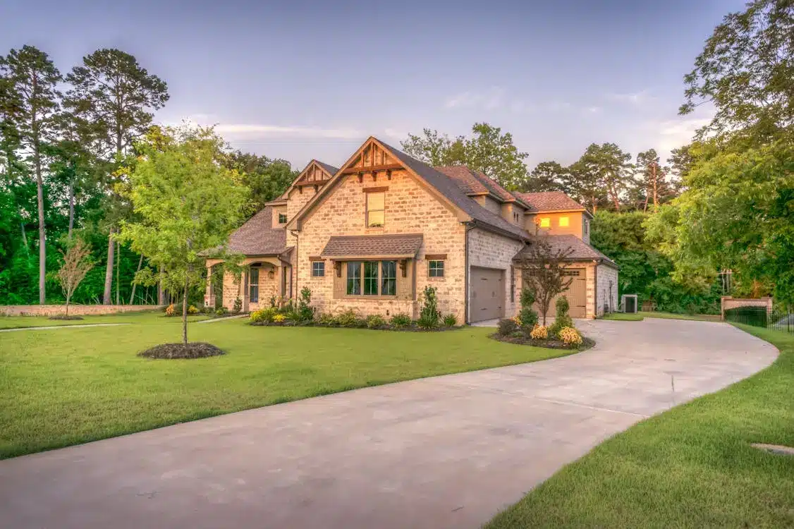 Stone house with gabled roof and landscaped front yard at dusk
