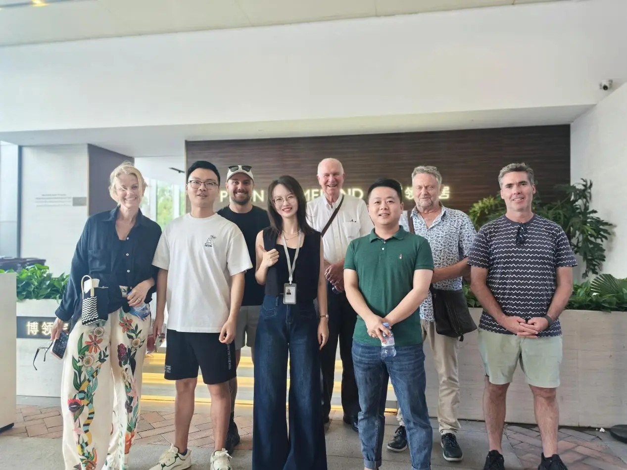 Group of people smiling indoors with plants and modern decor in background