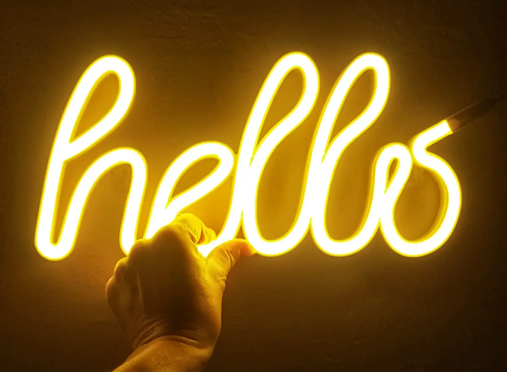 Neon sign in the shape of the word "hello" emitting warm yellow light