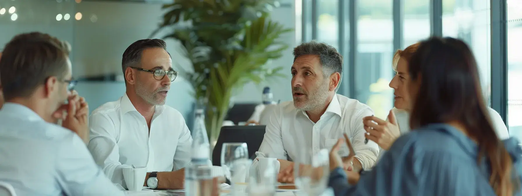Group of professionals in discussion around a table in a modern office setting