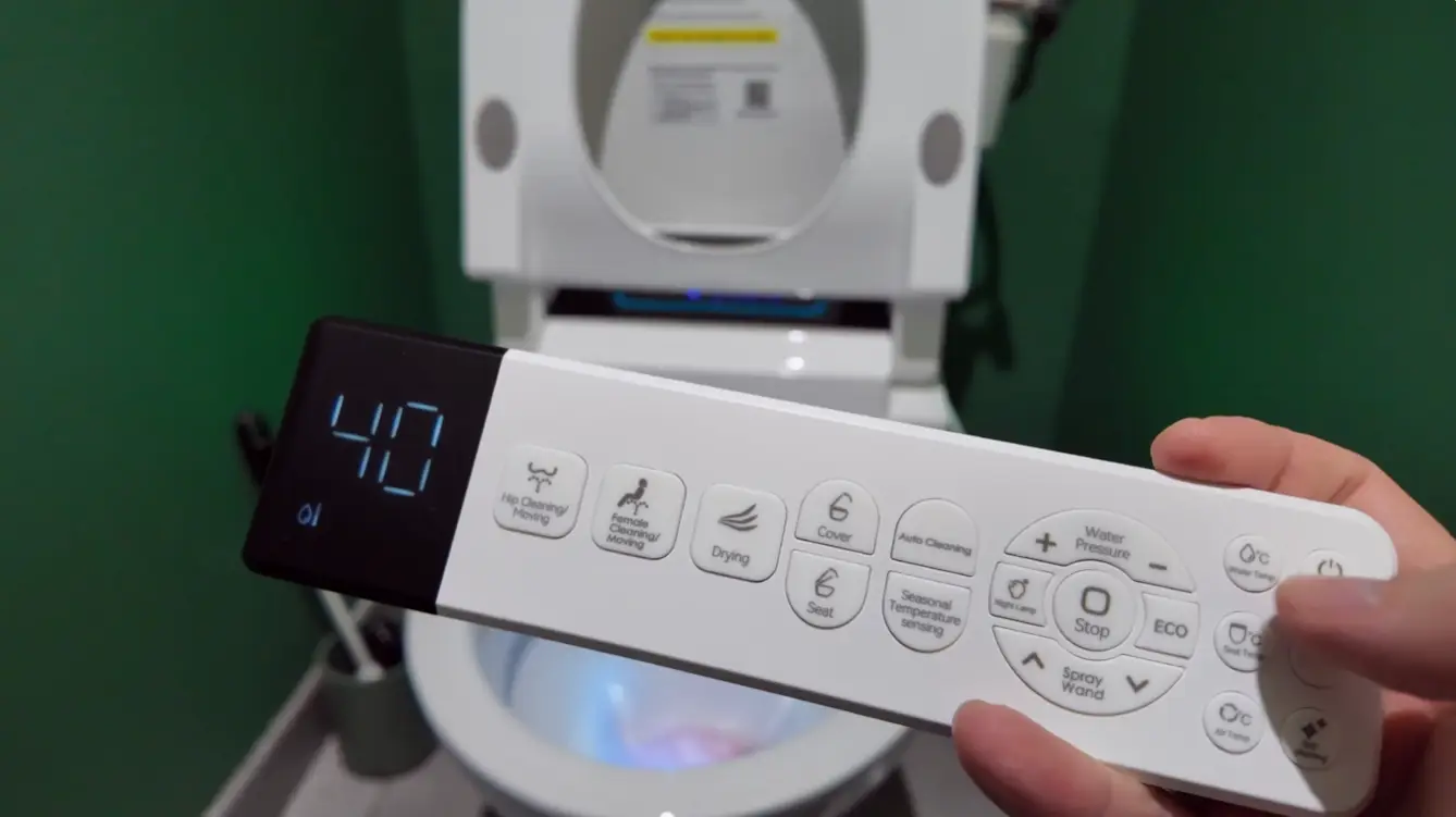 Modern bidet control panel with digital display and buttons in a green bathroom setting