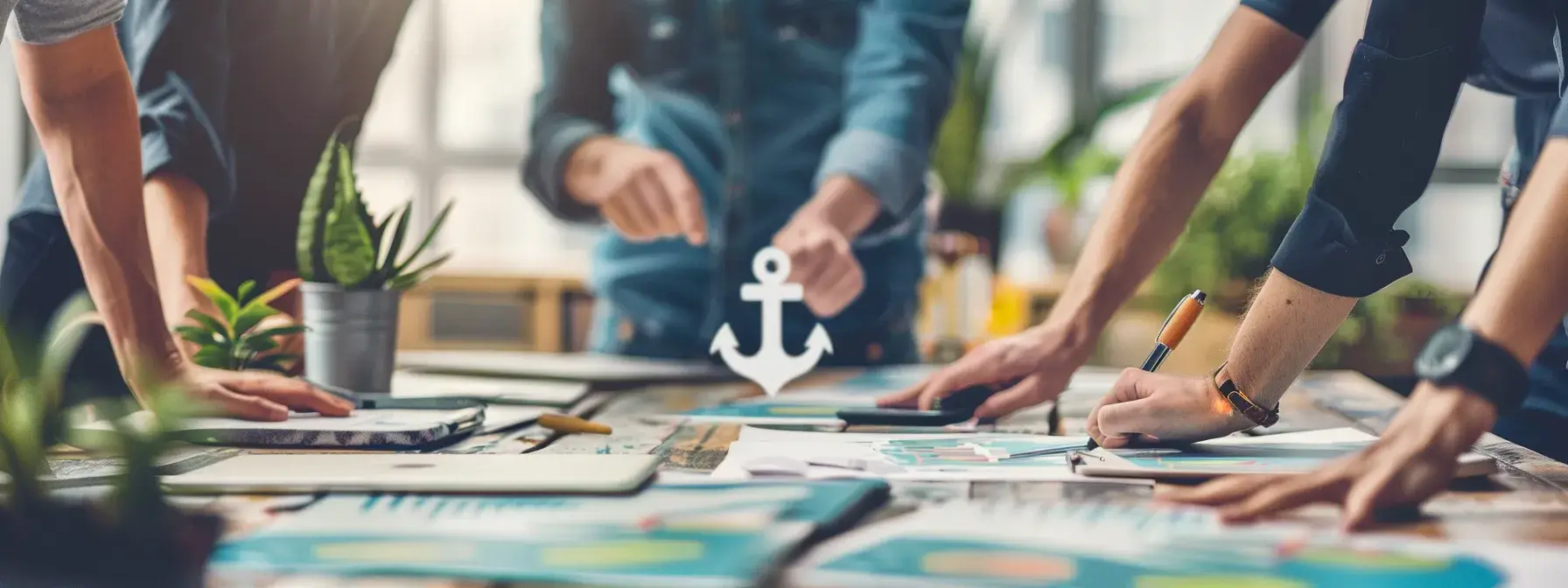 Collaborative team working at table with documents and potted plants in sunlit office