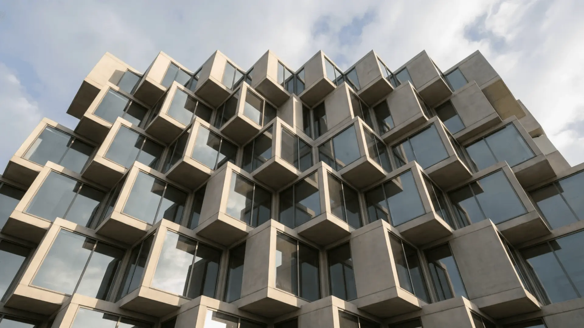 A low-angle view of a modern sculptural building with geometric lines and clean design.