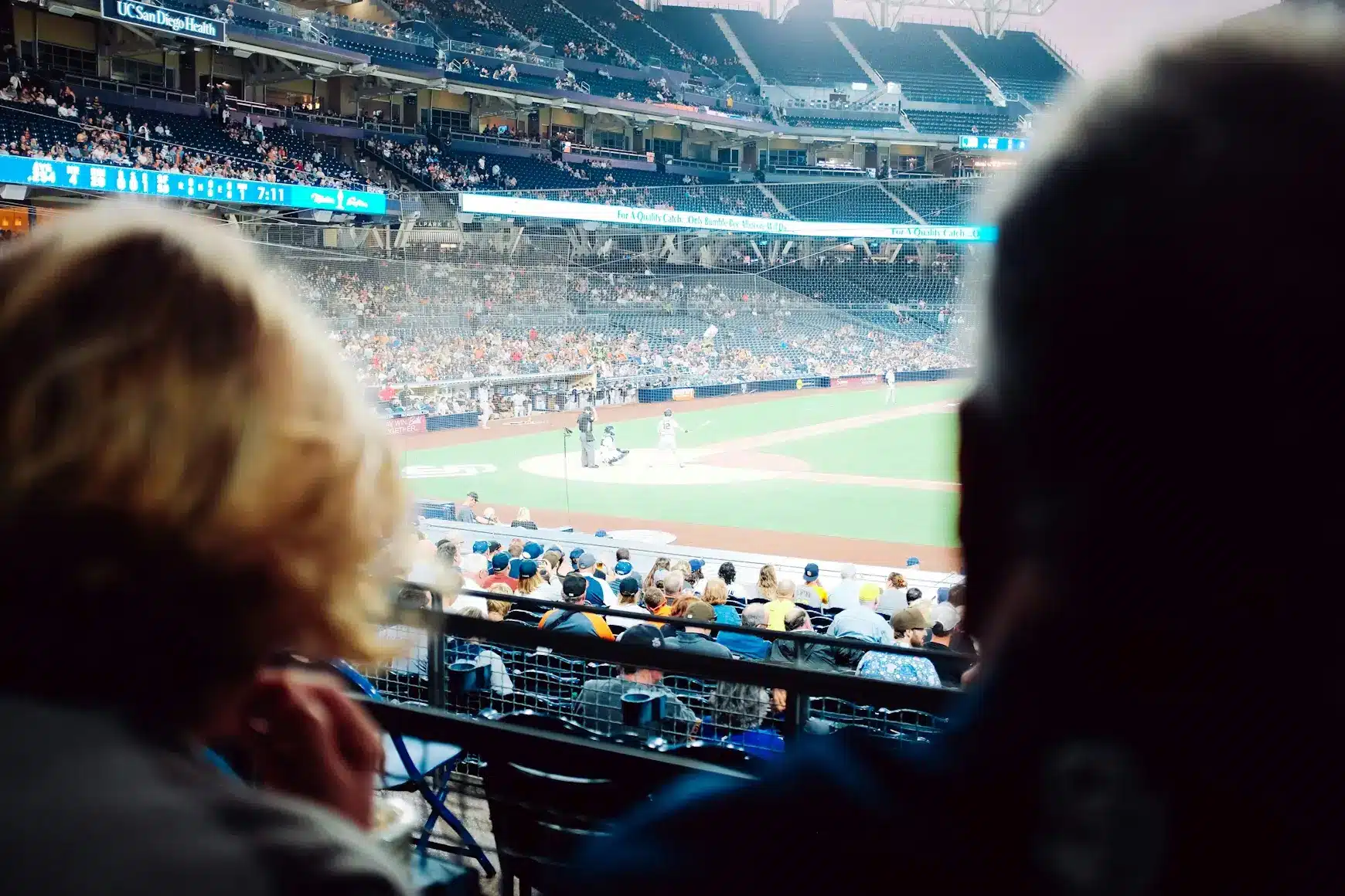 Spectators watching a baseball game from stadium seats with players on the field