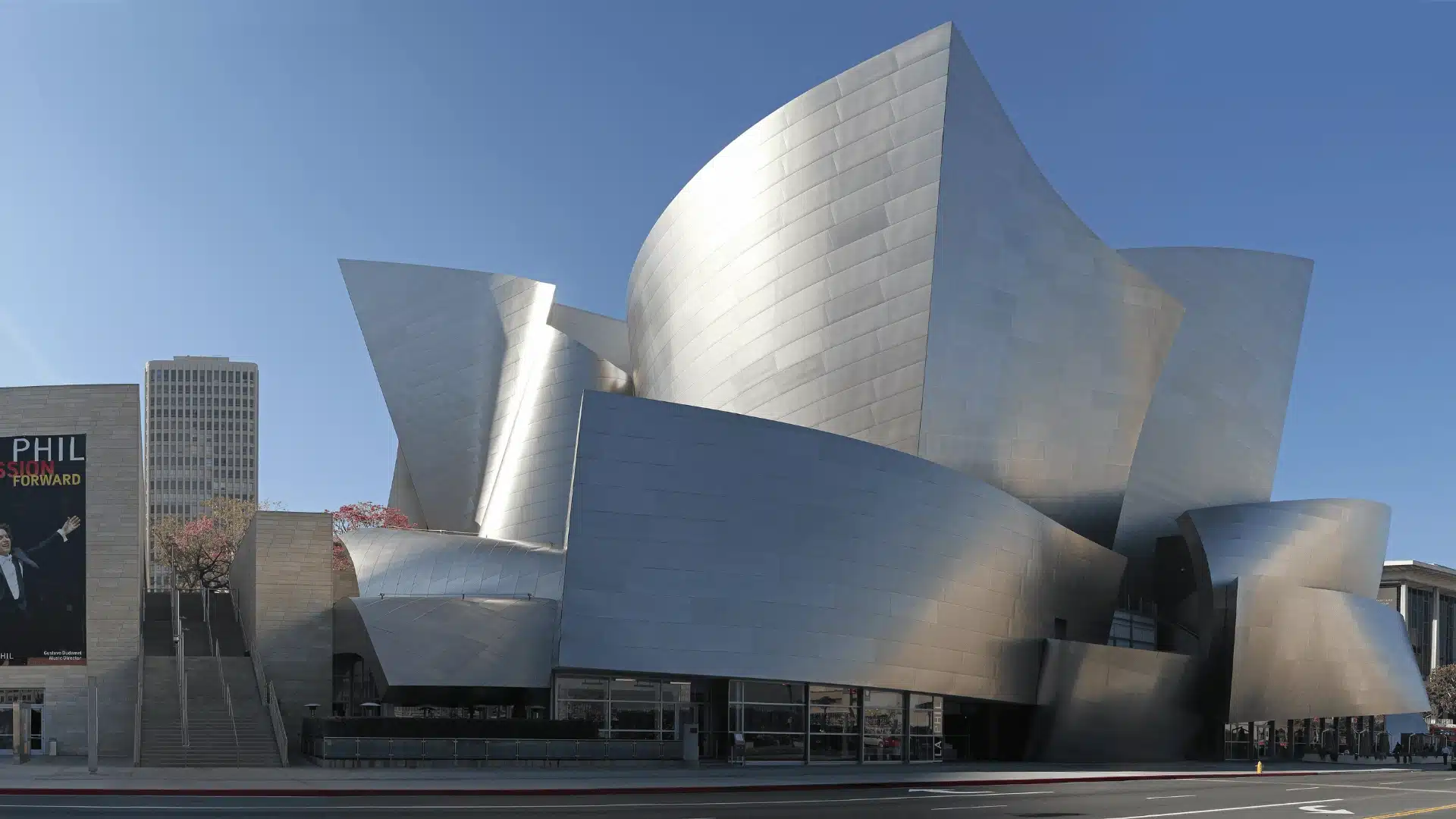 Walt Disney Concert Hall in Los Angeles, featuring Frank Gehry's dynamic, sculptural stainless steel exterior, with angular, sweeping forms.