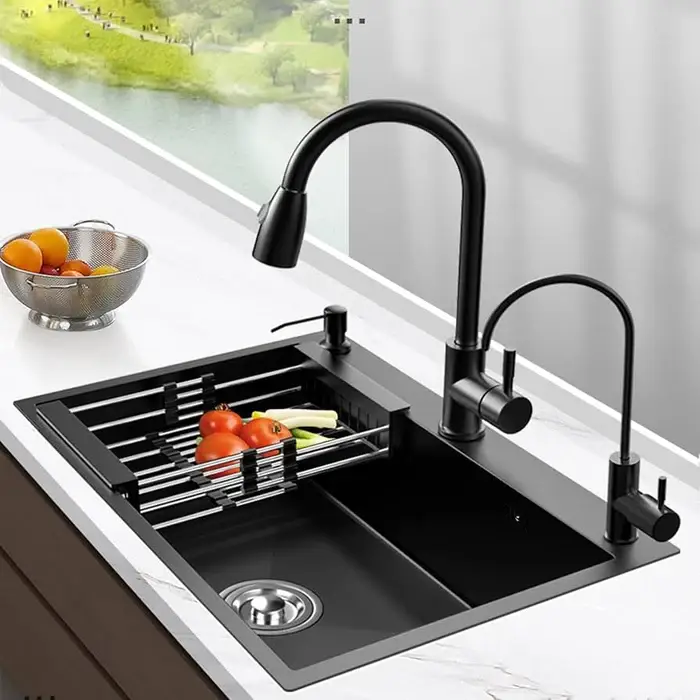 Black kitchen sink with dual faucets and drying rack on white countertop near large window