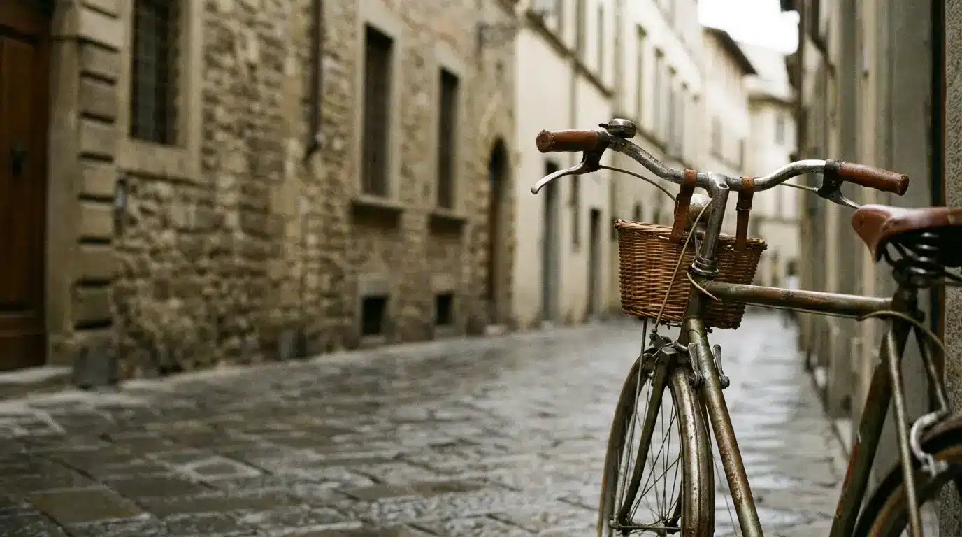 Vintage bicycle with rusted frame and wicker basket on narrow cobblestone street