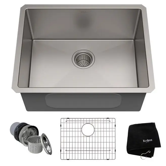 Stainless steel kitchen sink with drain accessories and protective grid on white background
