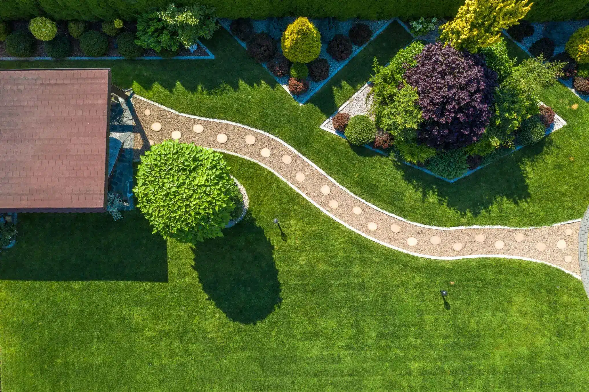 Aerial view of landscaped garden with winding stone path and lush green lawn