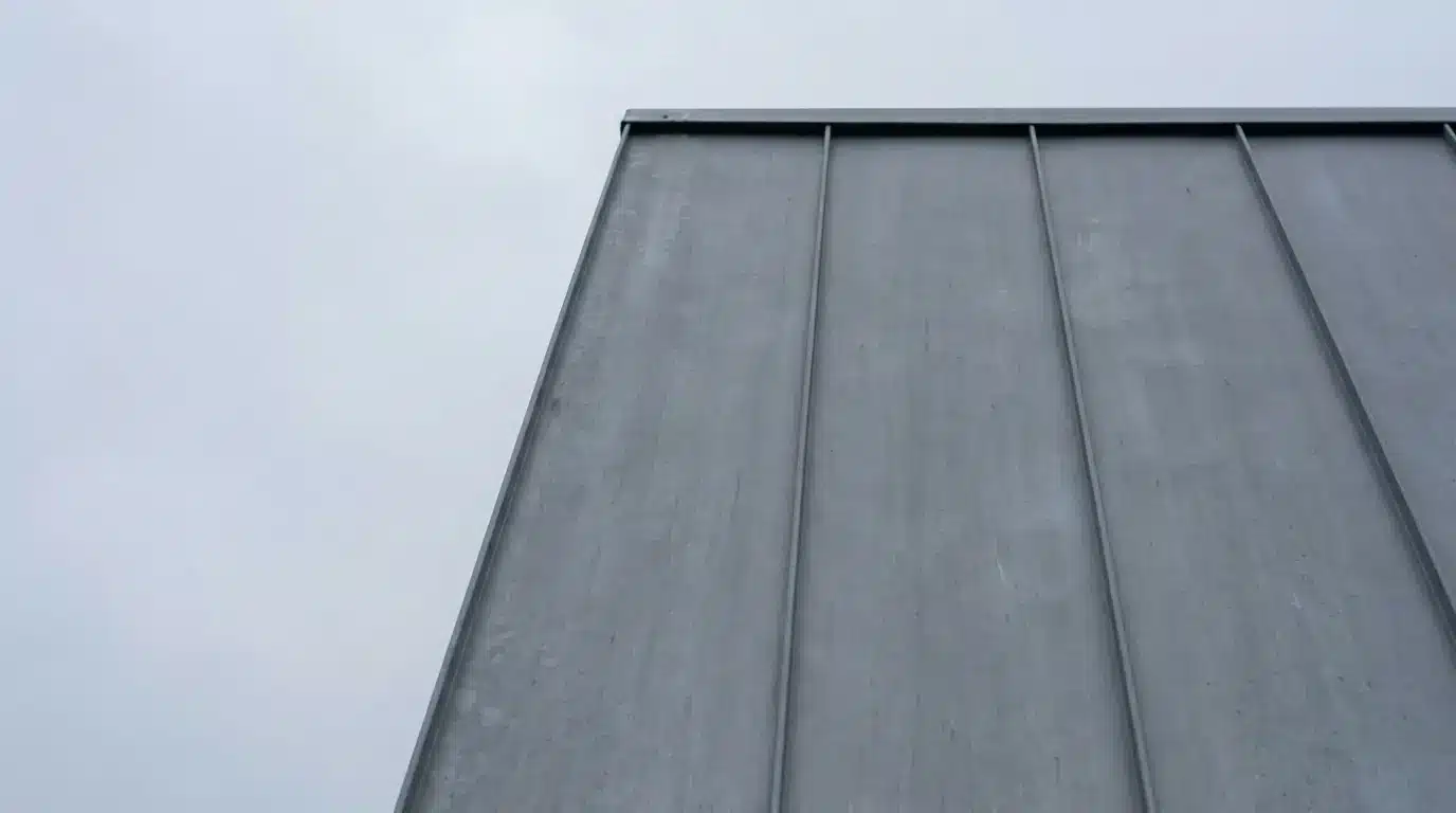 Metal siding on modern building facade against overcast sky