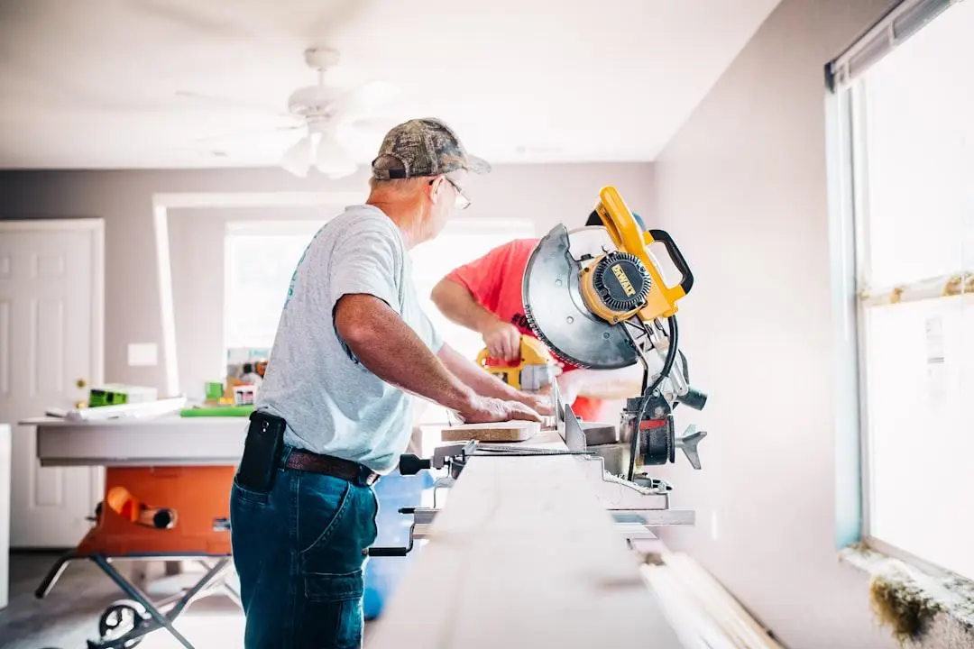 Man operating circular saw in bright home workshop with tools and wood nearby