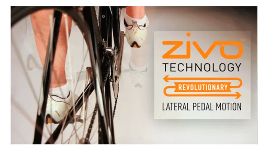 Cyclist's legs pedaling on bike with focus on rear wheel in indoor setting