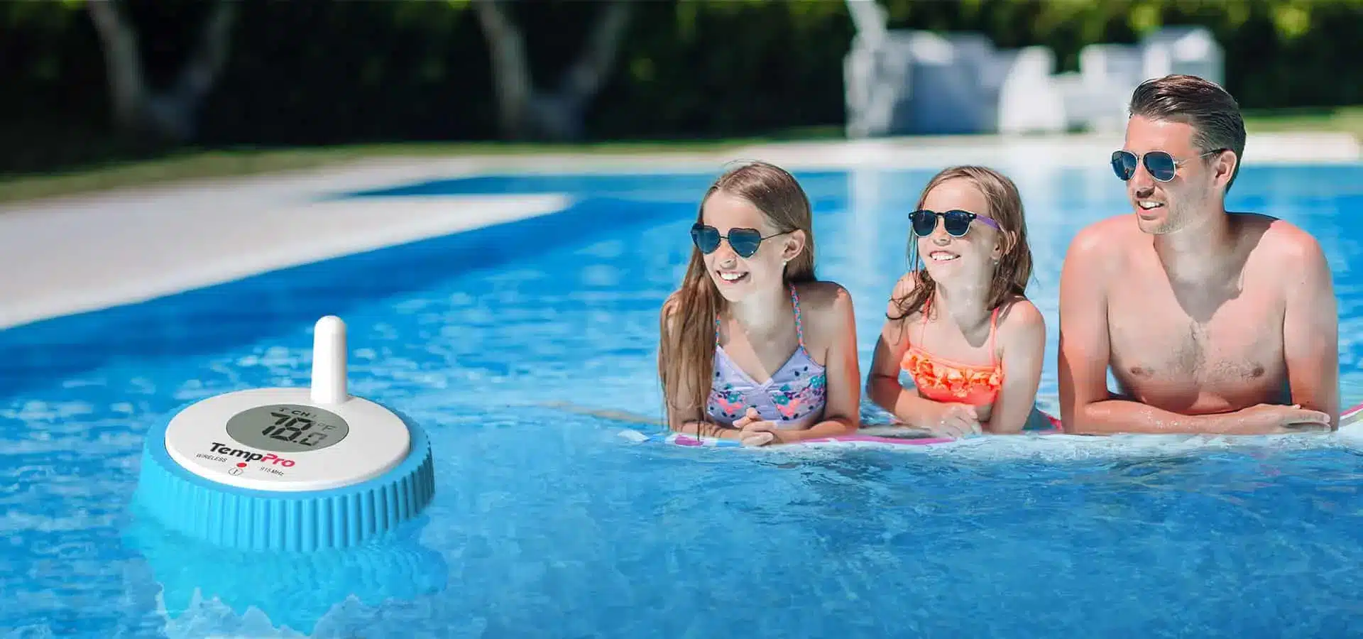 Floating pool thermometer near two children and an adult in sunglasses enjoying a sunny swim