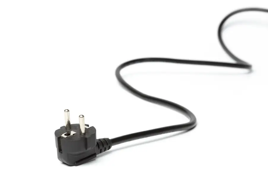Black electrical plug with long cord on white background, close-up view