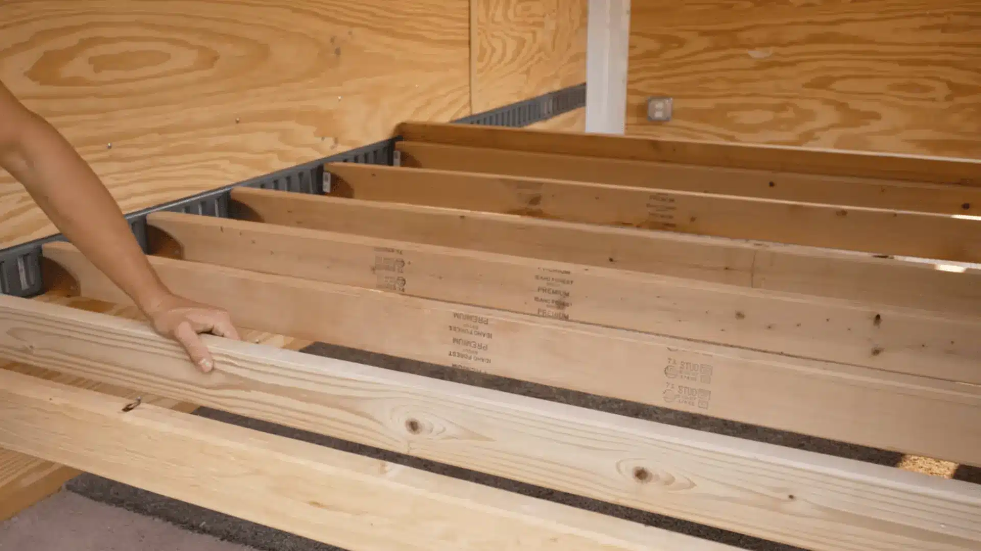 2x4 lumber supports placed across cargo trailer brackets for a removable bed frame.