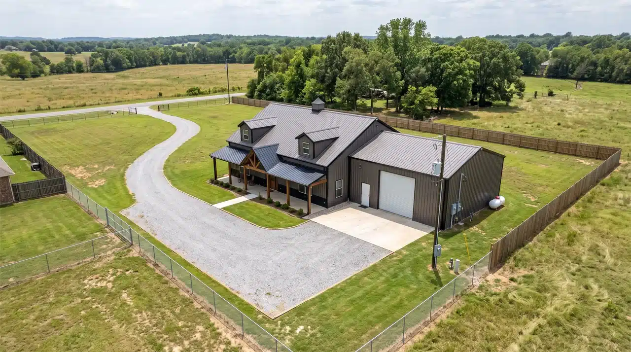 Barndominium on a residential parcel with driveway, utility access, workshop, and open setbacks around the building