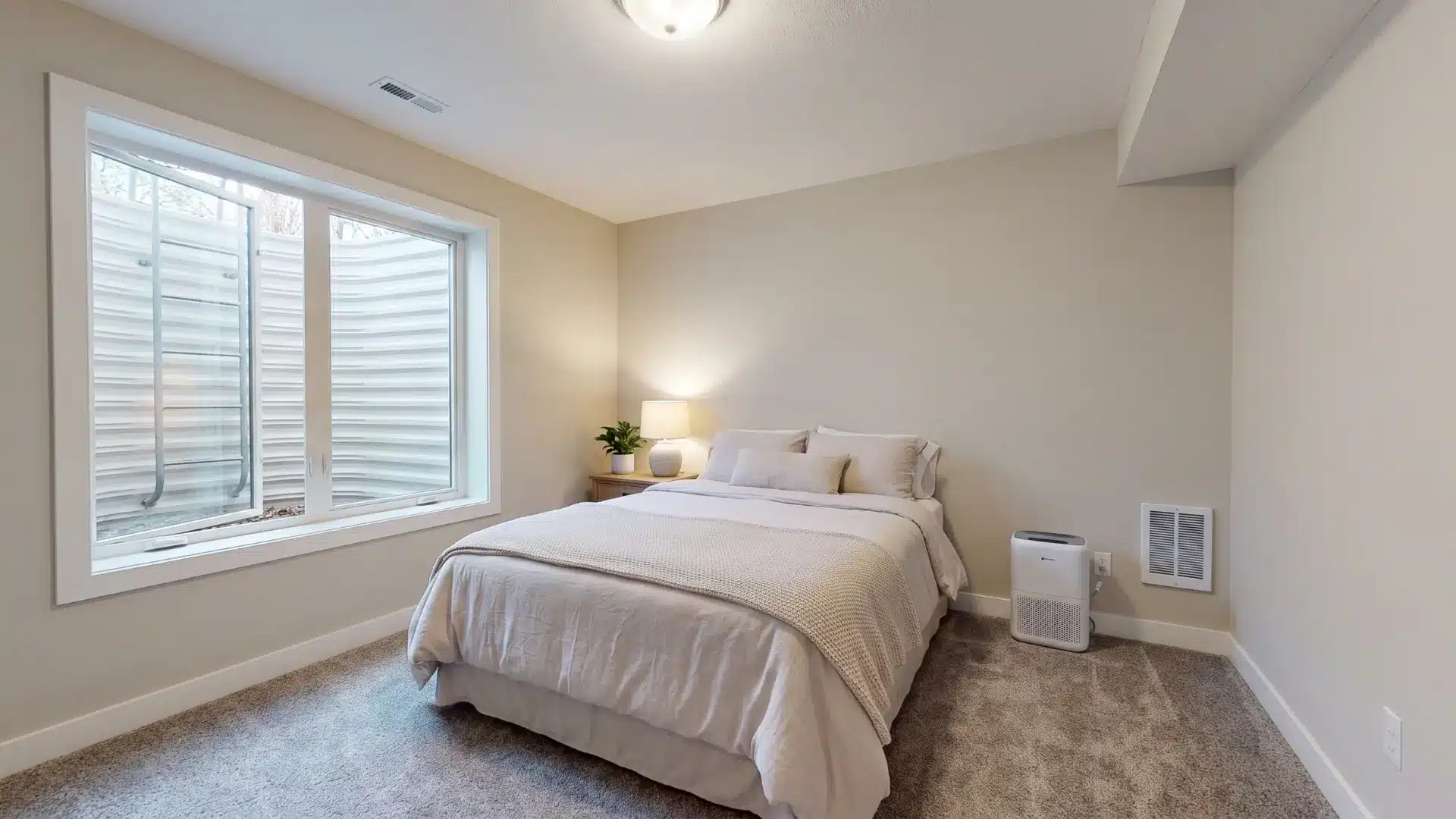 Basement bedroom with egress window and bed