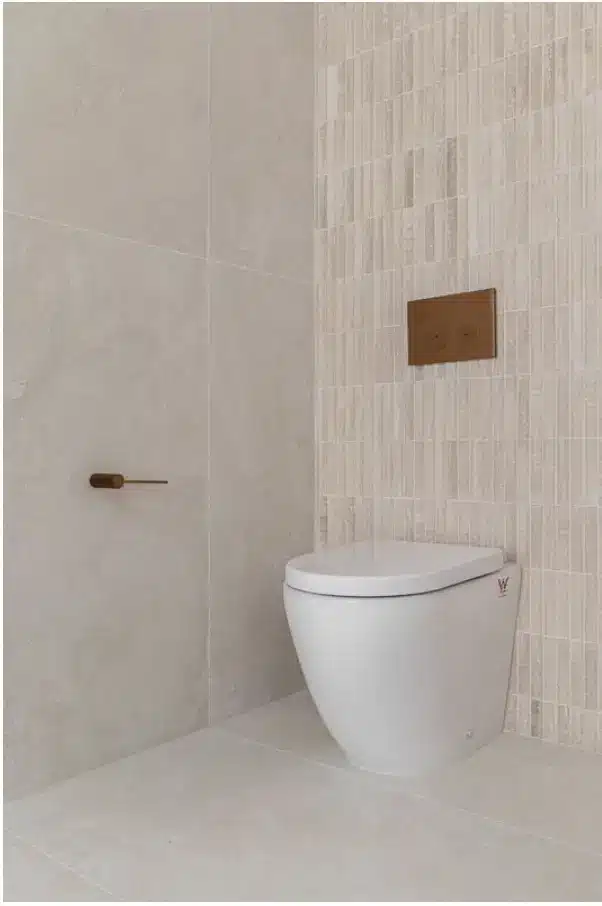 Modern bathroom with wall-mounted toilet and textured beige tiles