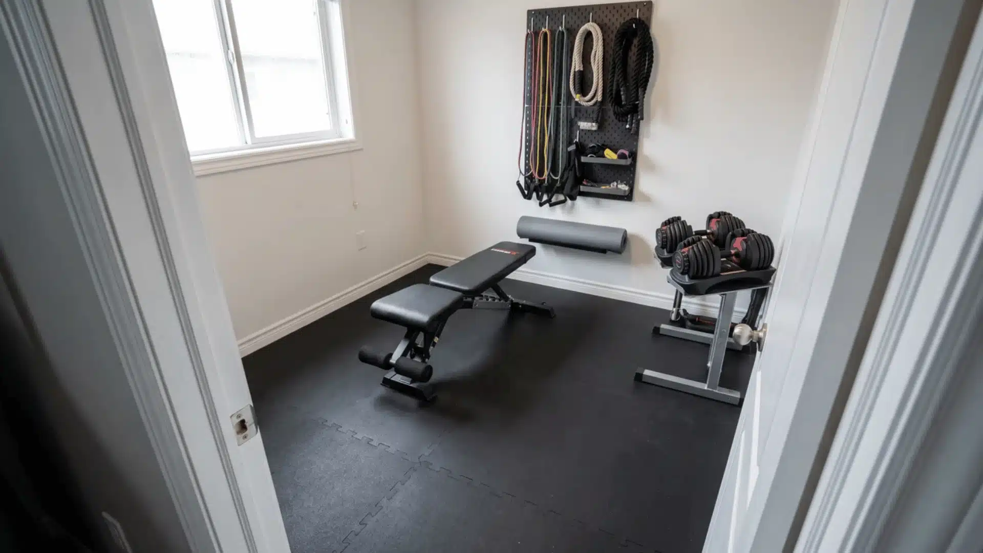 Compact small home gym with equipment storage and open workout space