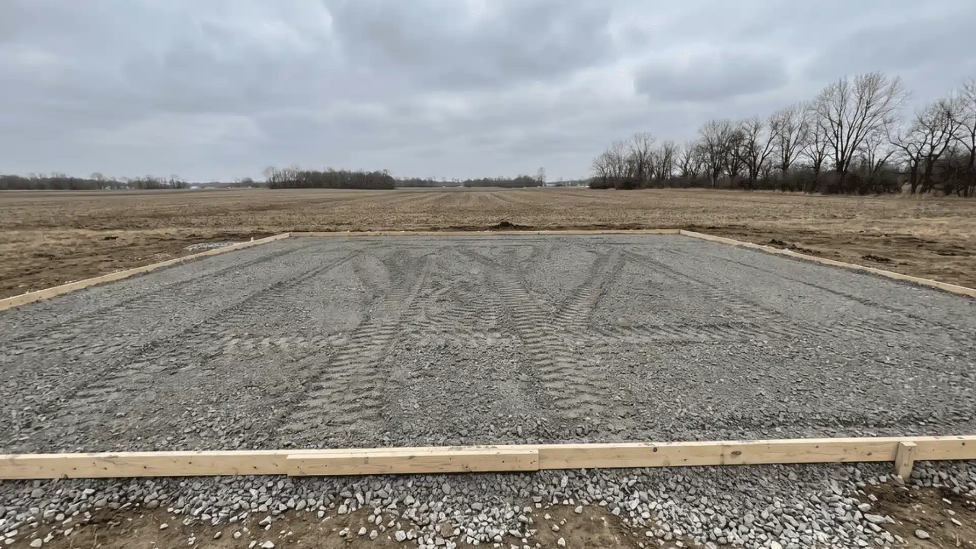compacted gravel subbase layer within wooden perimeter forms on a building pad Filename: slab-foundation-gravel-subbase-compaction