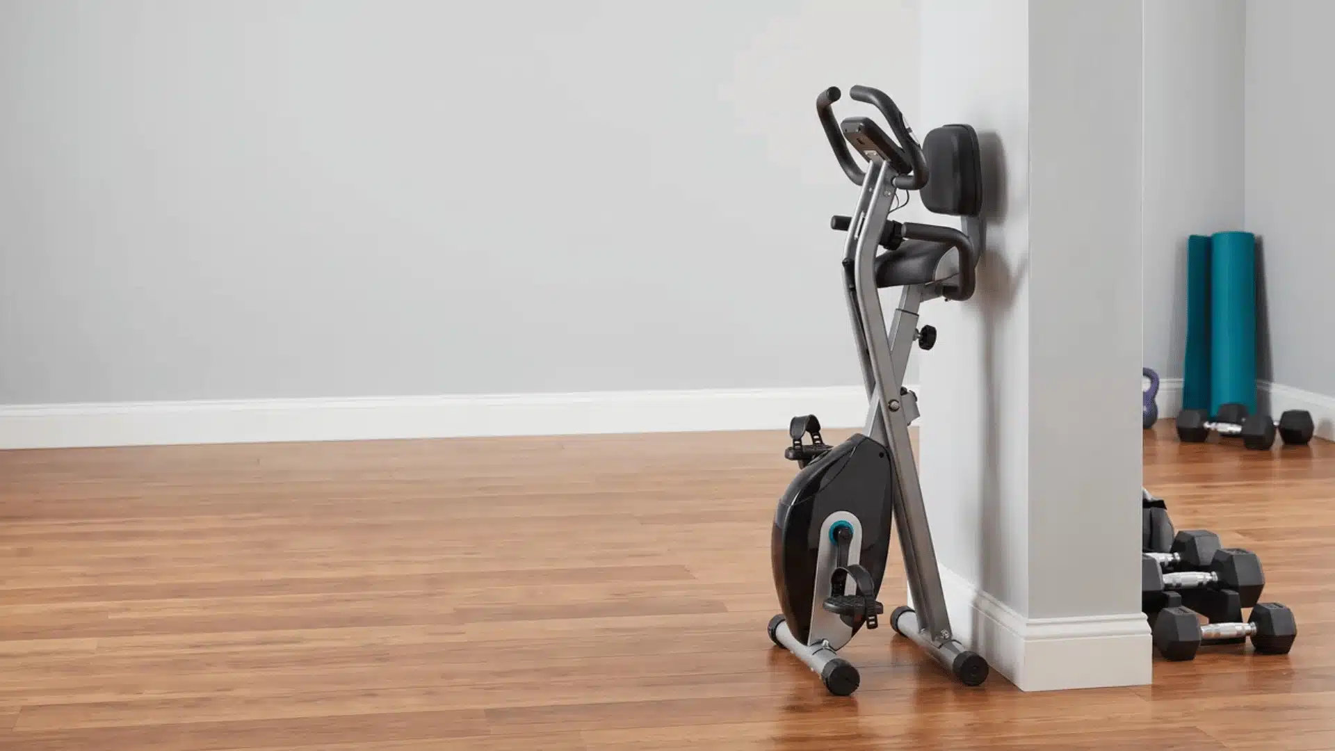 Foldable exercise bike stored against a gym wall