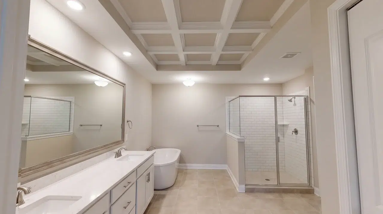 Full bathroom with a shallow coffered ceiling visible across the room.