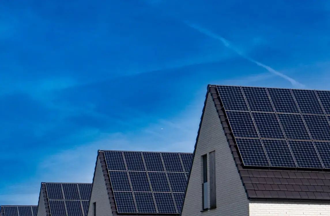 Rooftops with solar panels under clear blue sky