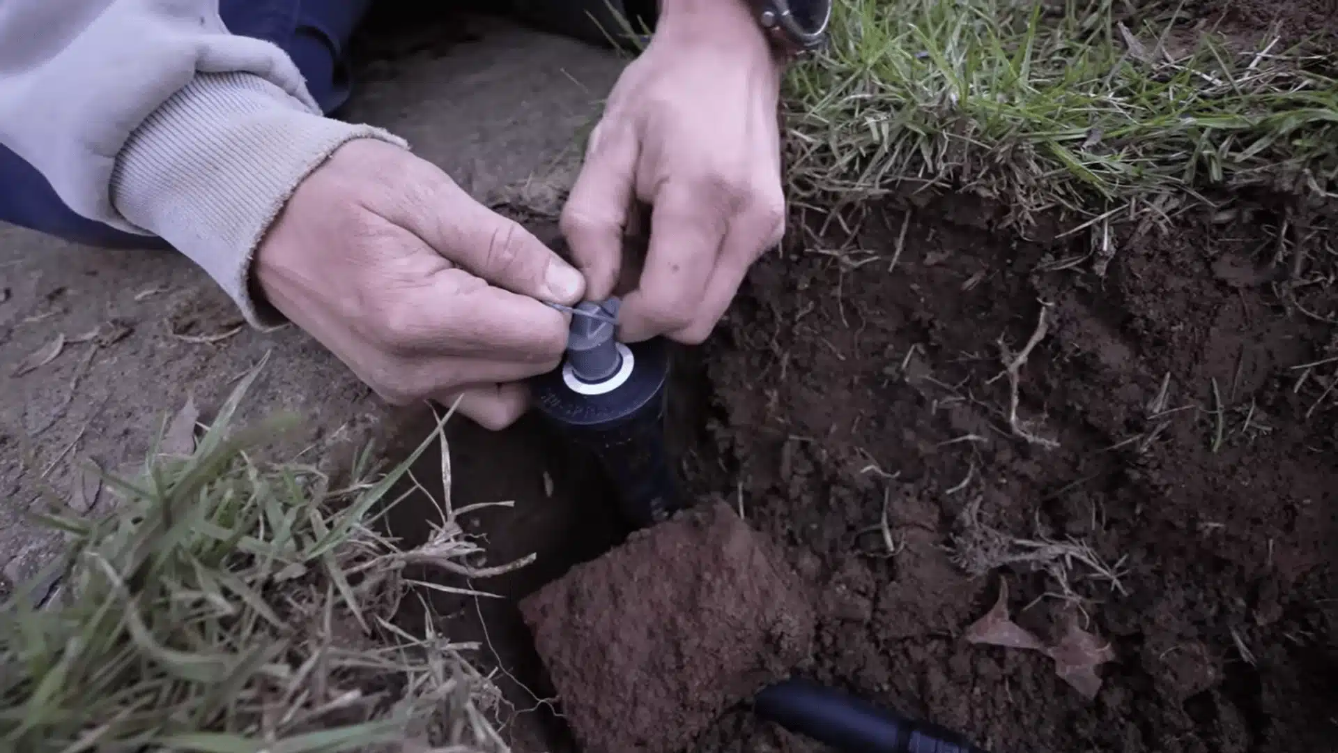 Installing a sprinkler nozzle into a buried sprinkler body after flushing the irrigation line.