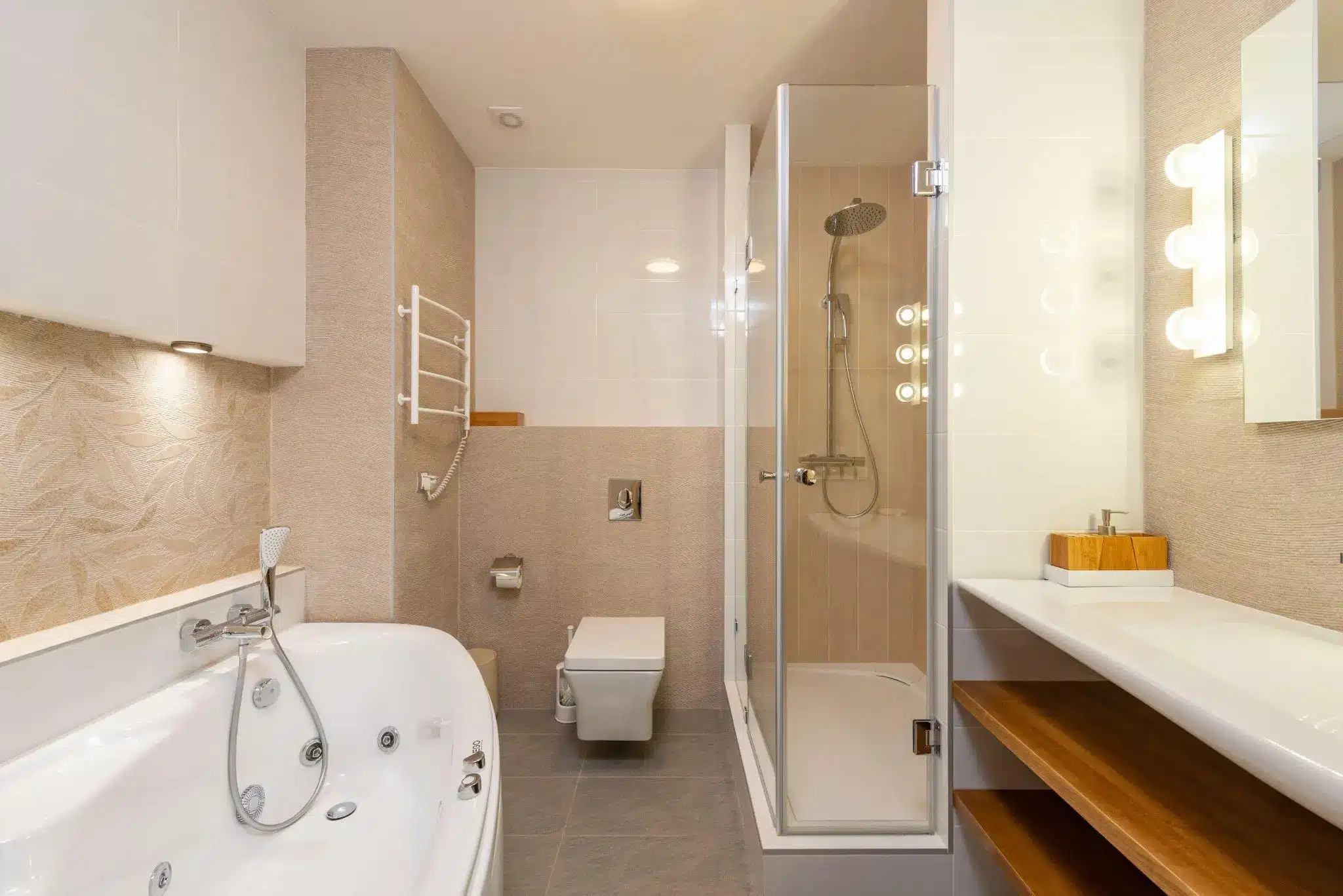 Modern bathroom with jacuzzi tub, glass shower, and vanity under soft lighting