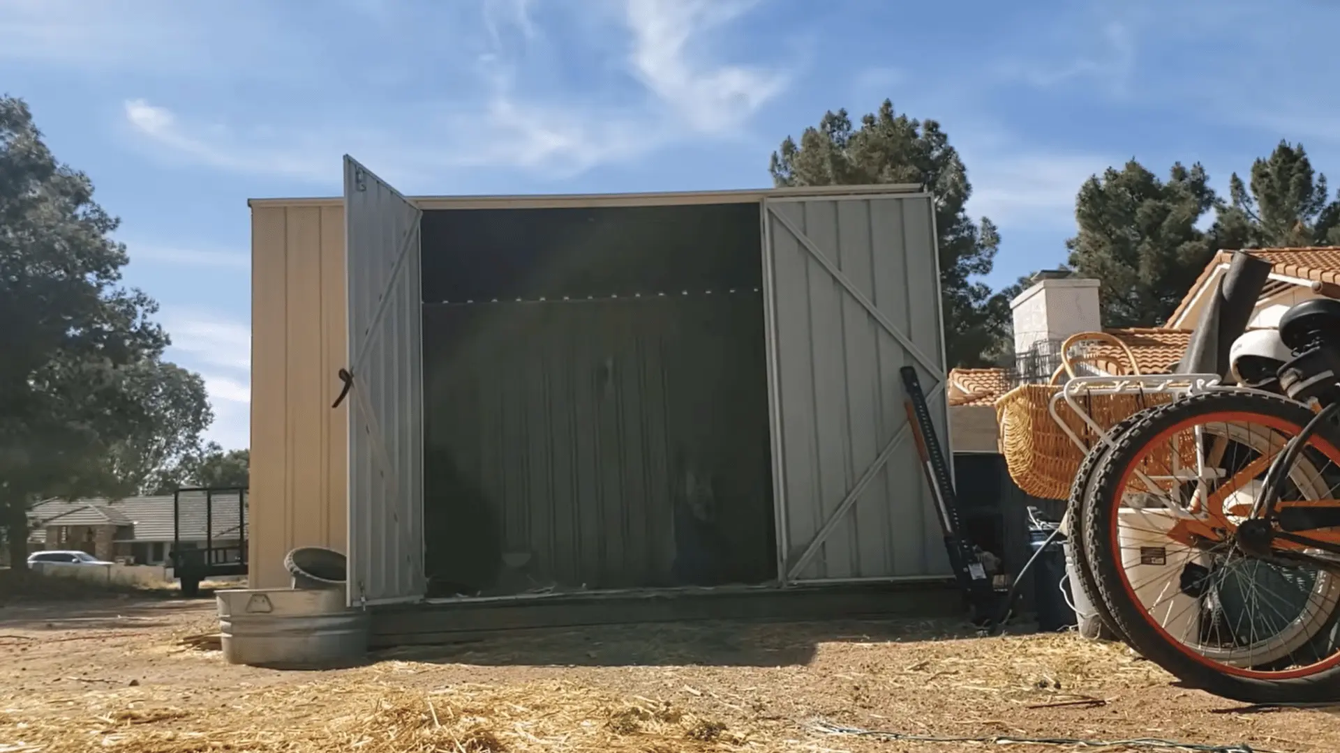 Open metal shed with most heavy items removed from inside before moving it.
