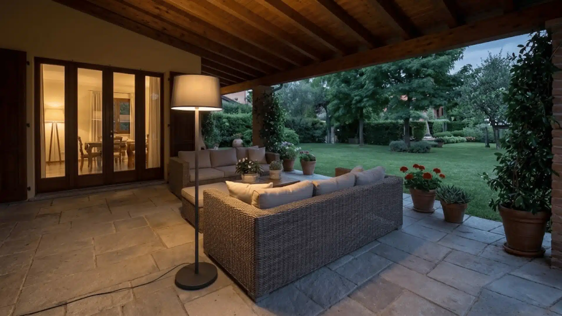 Outdoor floor lamp beside lounge seating on a covered patio