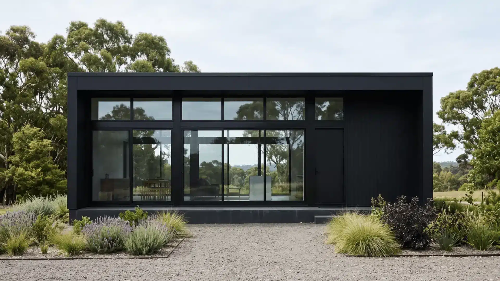 Rectangular black minimalist house with flat roof and large windows
