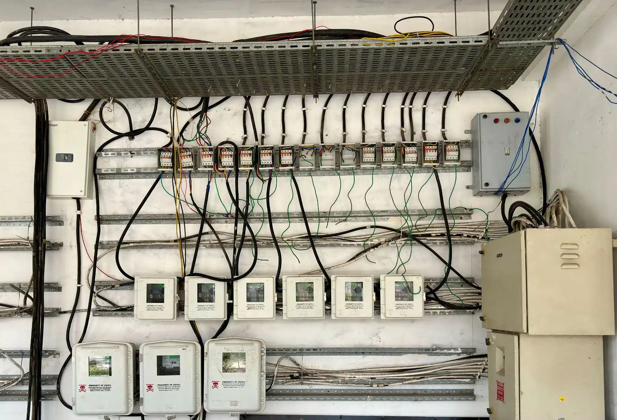 Electrical control panel with multiple meters and wires in industrial setting