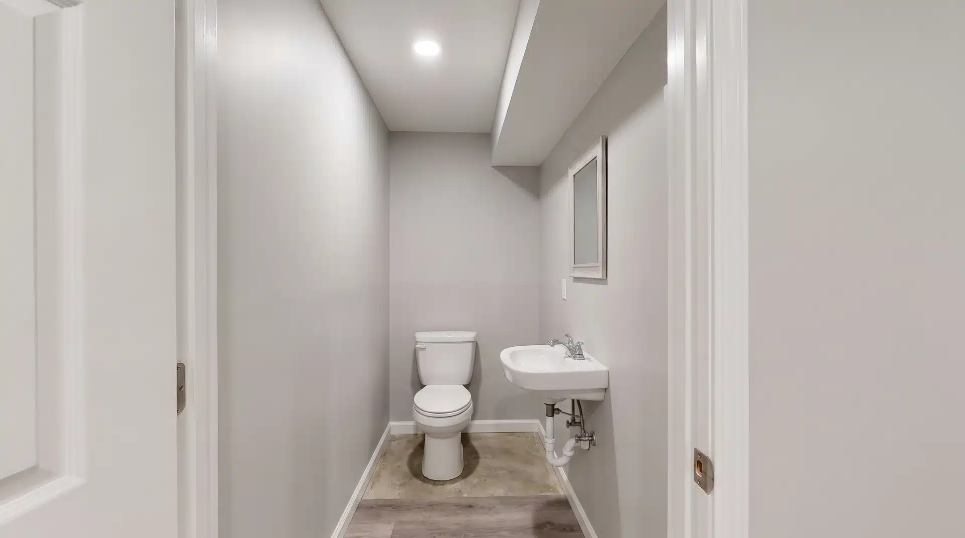 Small basement powder room with compact toilet and sink layout