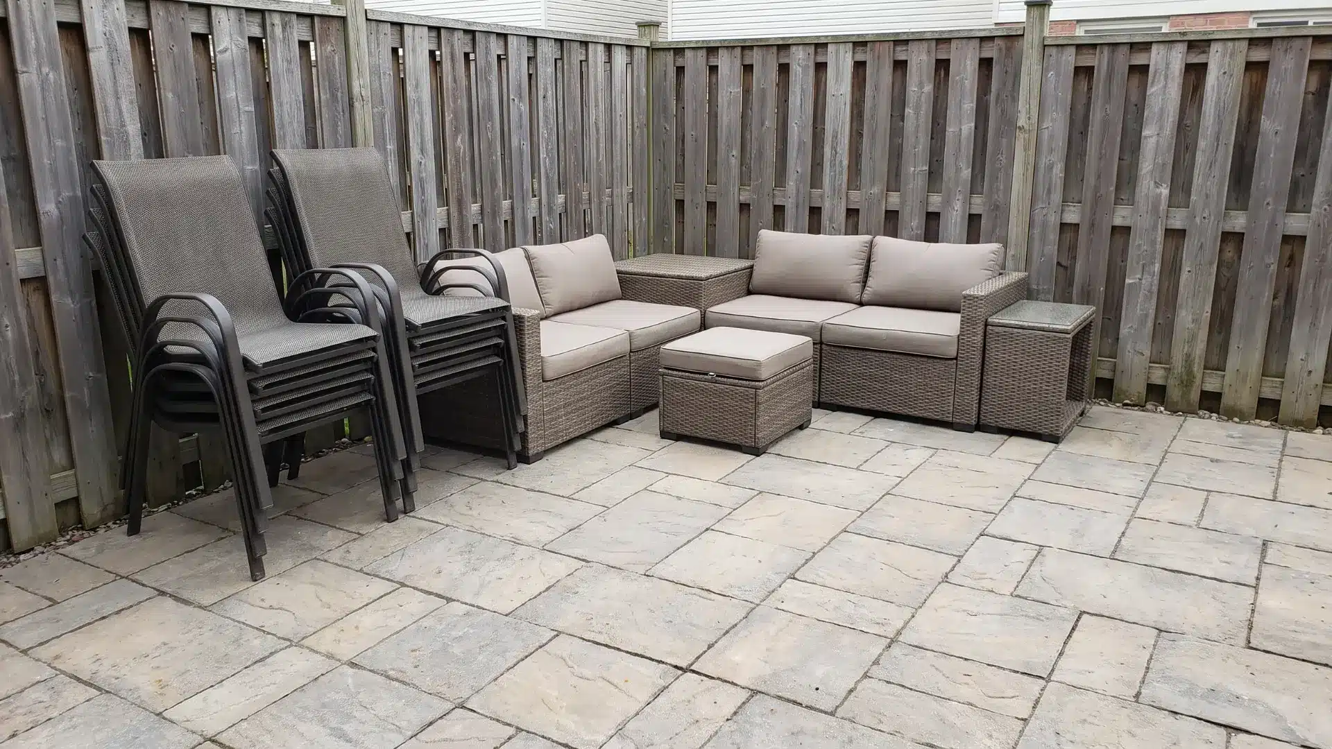 Stackable chairs and modular seating arranged compactly on a small patio