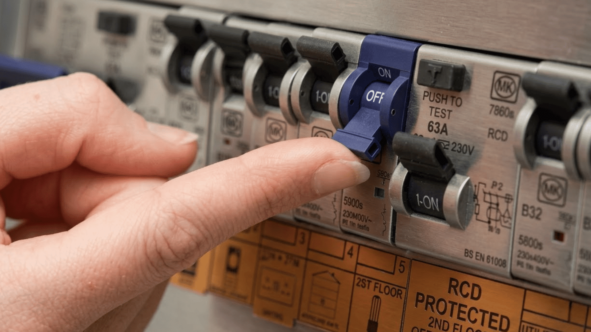 hand resetting a circuit breaker switch inside an electrical panel with multiple breakers