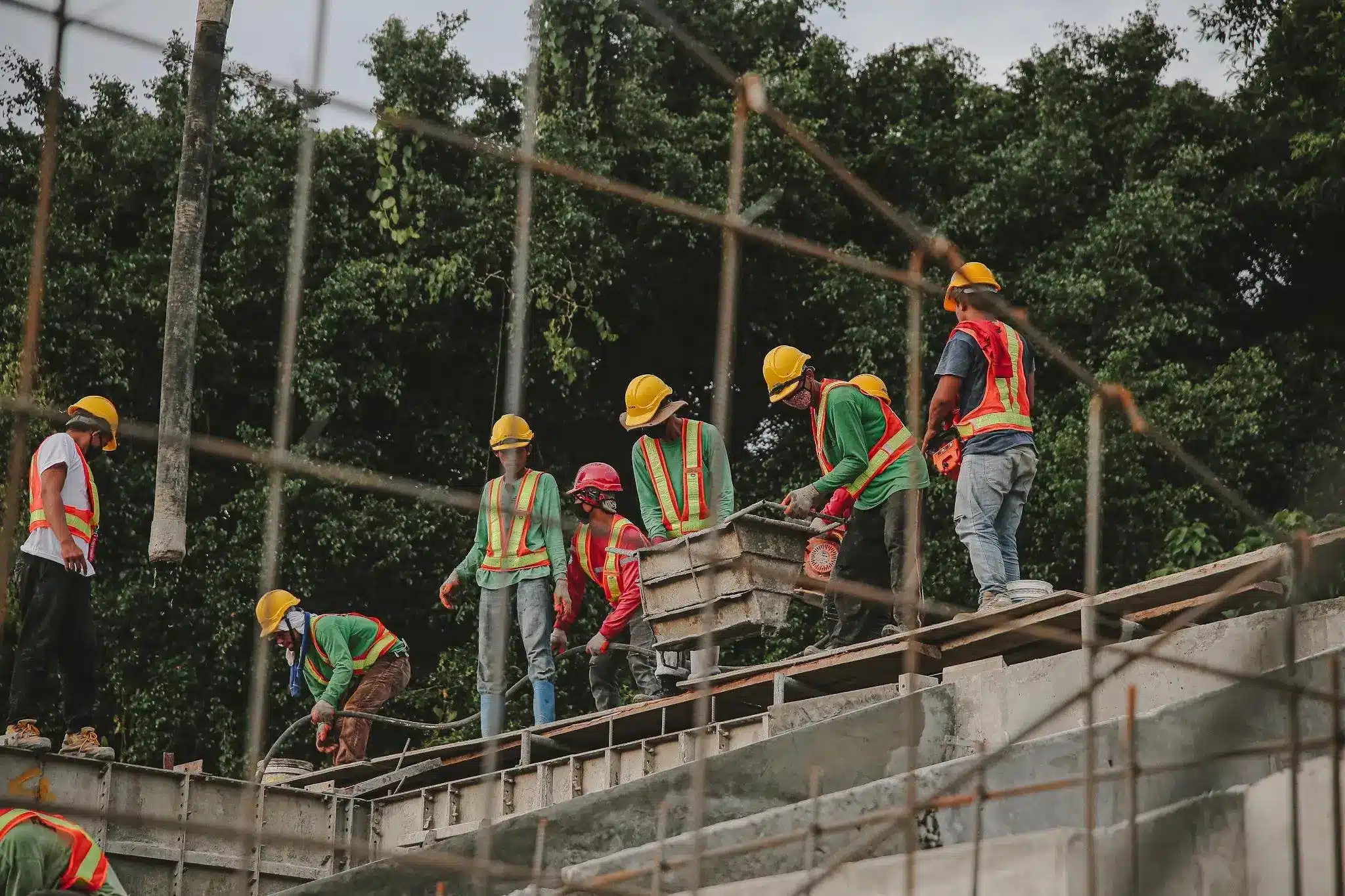 Construction workers in safety vests and helmets working on a building site outdoors