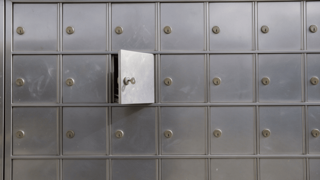 close-up of stainless steel po box units with brass keyholes and one box open with key inserted