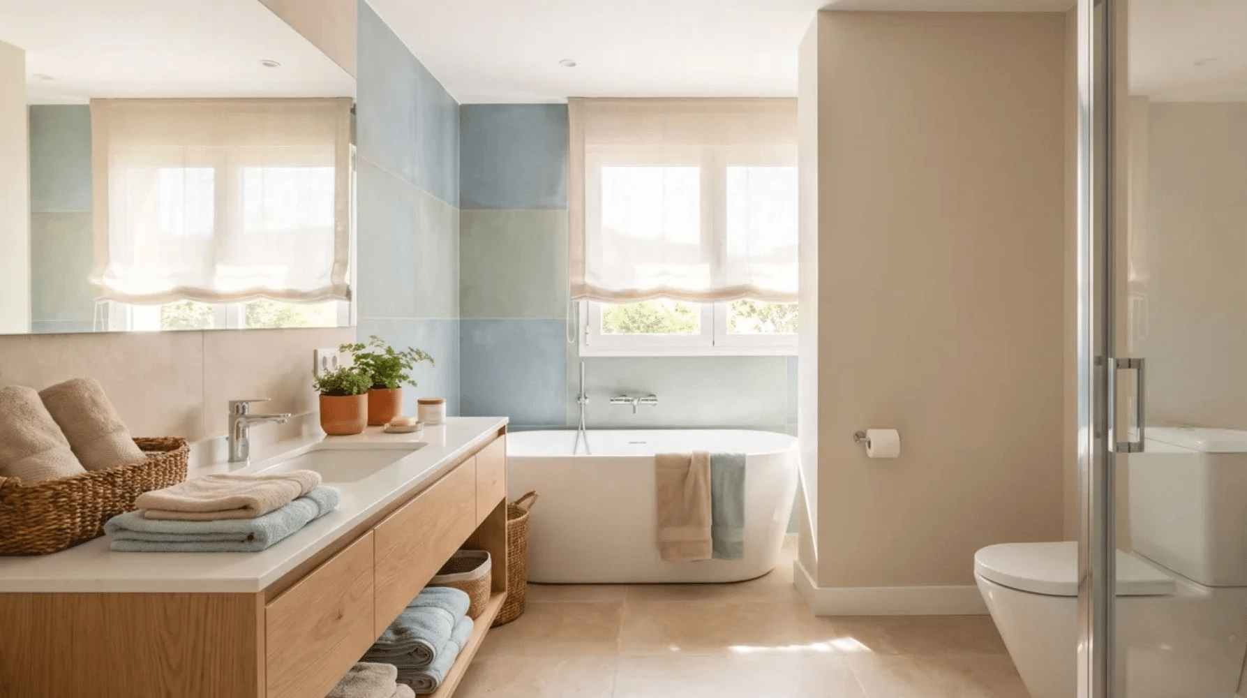 Calm bathroom interior with warm white, beige, muted blue, and soft green tones.