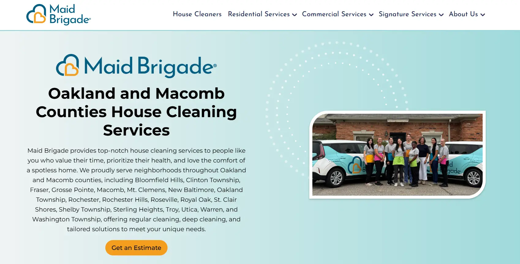 Group of cleaning staff standing beside Maid Brigade vehicles outdoors