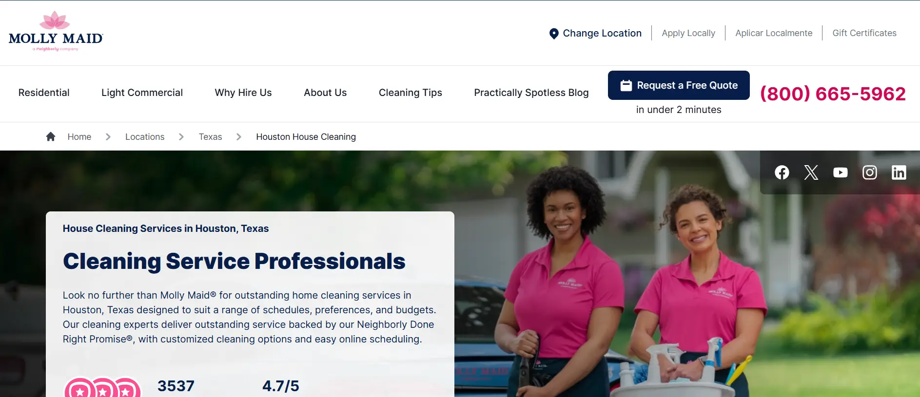 Two women in pink shirts holding cleaning supplies outdoors in a residential area