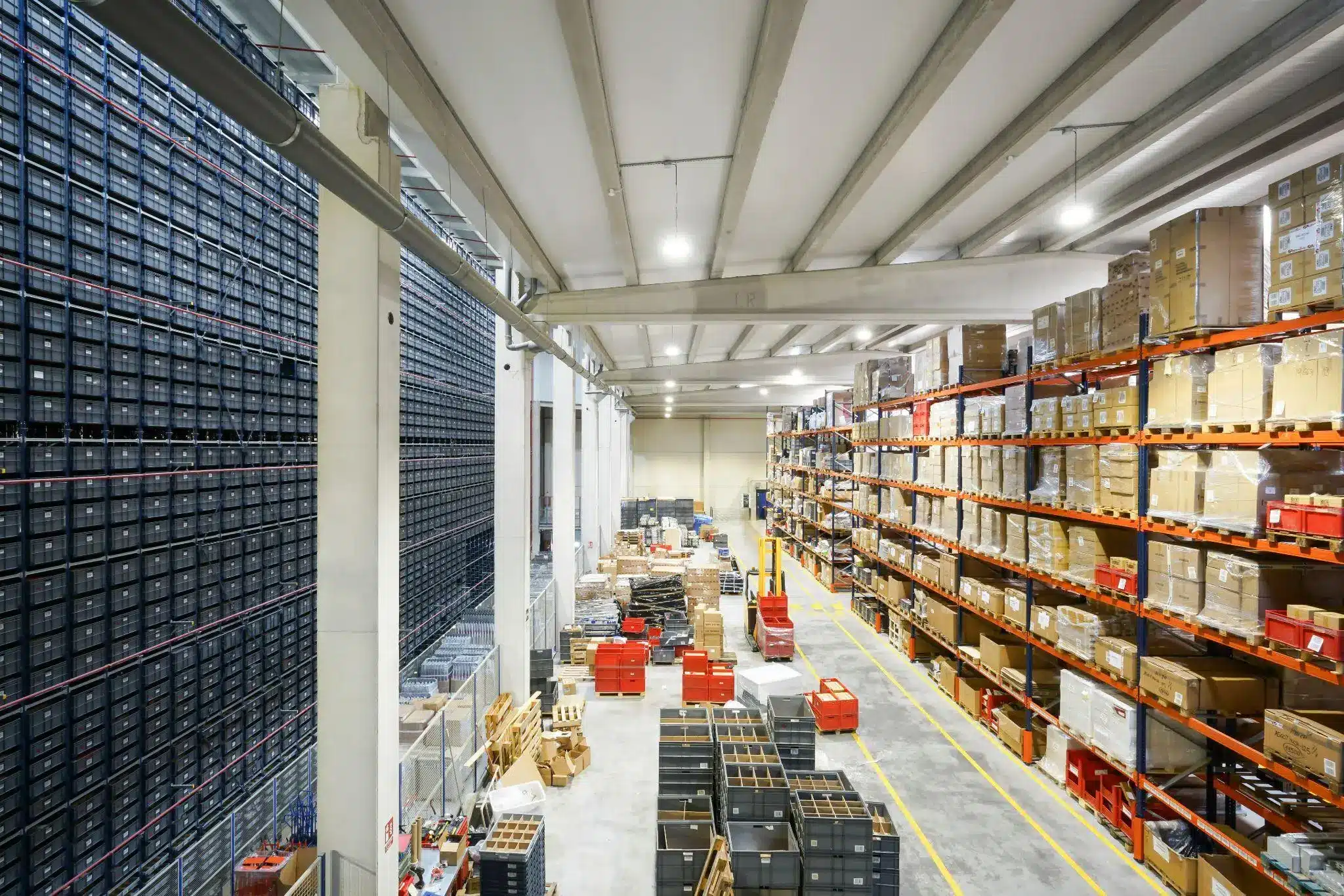 Warehouse interior with stacked shelves of boxes and crates under bright industrial lighting