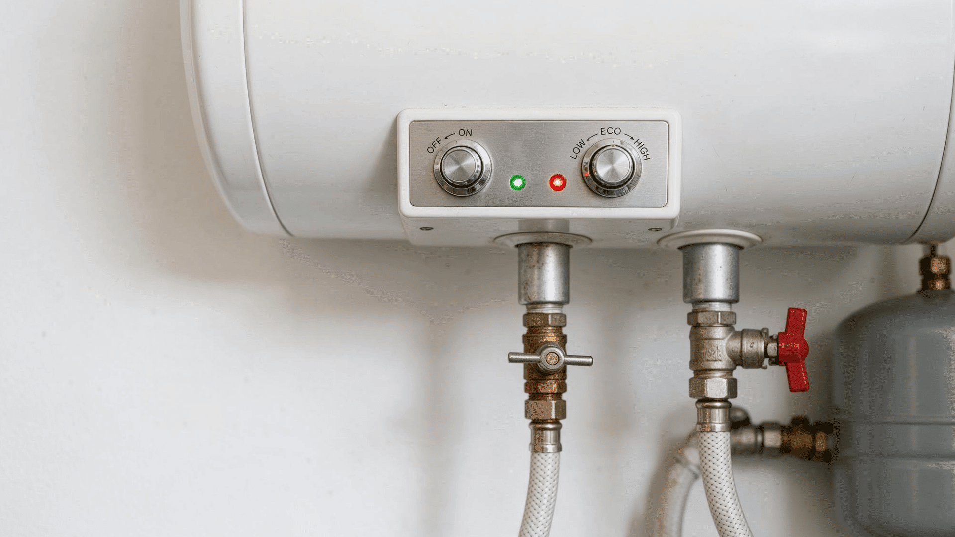 close-up of an electric water heater control panel with power and temperature dials